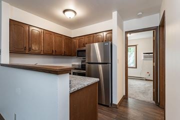 Stevens Point apartment for rent - a kitchen with wooden cabinets and a stainless steel refrigerator