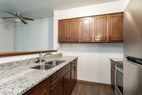 Stevens Point apartment for rent - an empty kitchen with granite counter tops and a stainless steel refrigerator