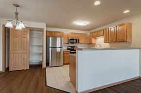 Plover apartment for rent - a kitchen with a white island and a stainless steel refrigerator