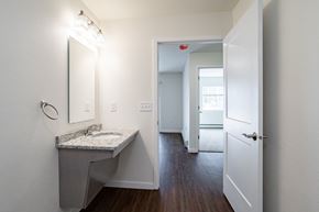 Plover apartment for rent - a bathroom with a sink and mirror and a hallway with a door to a bedroom