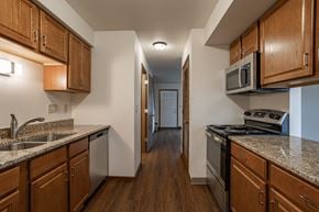 Stevens Point apartment for rent - a kitchen with wood cabinets and granite counter tops and a stove and a microwave