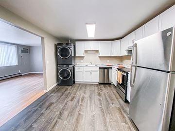 Madison apartment for rent - a kitchen with white cabinets and stainless steel appliances and a washer and dryer