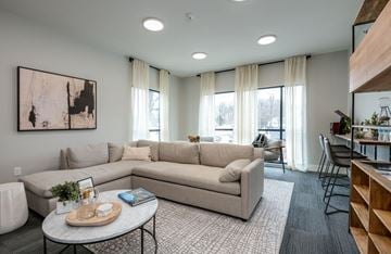 Brookfield apartment for rent - A living room with a large beige sofa, a coffee table, and a painting on the wall.