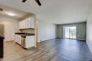 Racine apartment for rent - A kitchen with white cabinets and a black refrigerator.
