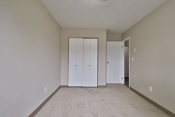 Appleton apartment for rent - a living room with white walls and a carpet and two closets