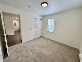 Janesville apartment for rent - A room with a carpeted floor and a door leading to another room.