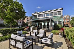 Milwaukee apartment for rent - a patio with chairs and tables and a building in the background