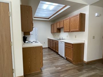 Wisconsin Rapids apartment for rent - A kitchen with wooden cabinets and a white fridge.