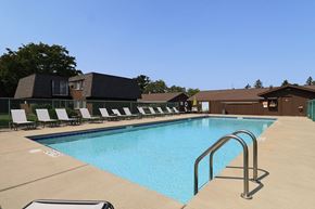Stevens Point apartment for rent - a swimming pool with chairs around it in front of a building