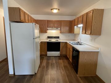 Menasha apartment for rent - A kitchen with wooden cabinets and a white refrigerator.
