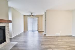 New Berlin apartment for rent - A living room with a fireplace and a ceiling fan.