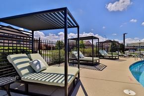 Oak Creek apartment for rent - A poolside area with sun loungers and a metal fence.