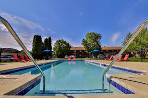 Milwaukee apartment for rent - A swimming pool with a blue sky and trees in the background.