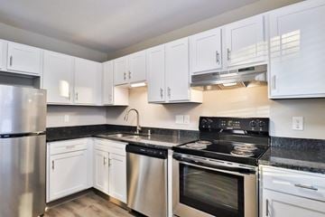 New Berlin apartment for rent - A kitchen with white cabinets and a black stove top.