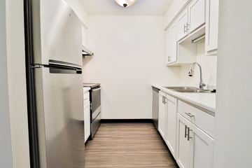 Brookfield apartment for rent - A kitchen with white cabinets and a stainless steel refrigerator.