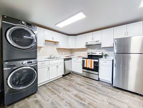 Madison apartment for rent - A modern kitchen with a washer and dryer stacked on top of each other.