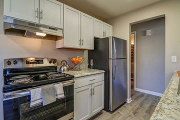 Madison condo for rent - A kitchen with a black stove top oven and a black refrigerator.