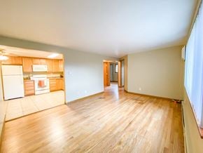Madison condo for rent - A room with wooden floors and a kitchen area to the left.