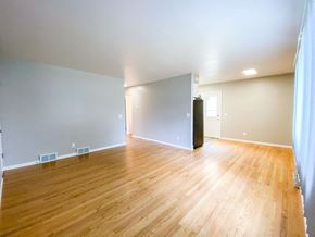 Madison apartment for rent - the living room and dining room of an empty house with wood floors