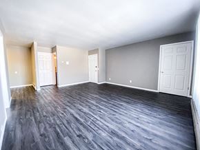Madison apartment for rent - an empty living room with wood floors and white doors