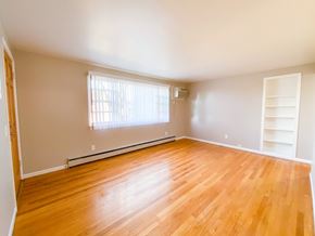 Madison condo for rent - A room with wooden flooring and a window with blinds.