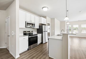 Waunakee apartment for rent - A modern kitchen with white cabinets and stainless steel appliances.