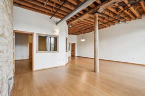Milwaukee apartment for rent - a large living room with wood floors and a exposed brick wall