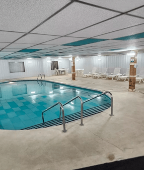 De Pere apartment for rent - A large indoor swimming pool with a blue tiled edge and a metal ladder.