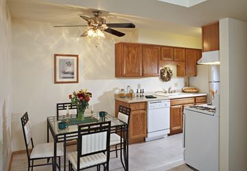 Greenfield apartment for rent - A kitchen with a table and chairs and a fridge.