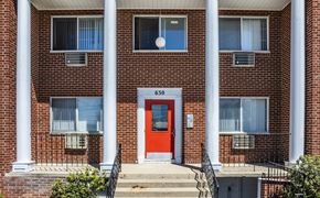 Madison apartment for rent - A red door is the centerpiece of a brick building with white columns.