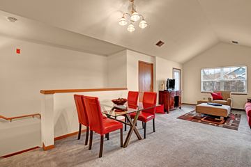 Milwaukee apartment for rent - A living room with red chairs and a grey carpet.