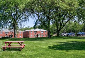 Madison apartment for rent - a picnic table in a park in front of a brick building