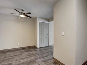 Hartland apartment for rent - an empty living room with a ceiling fan and a door