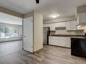 Hartland apartment for rent - an empty kitchen with white cabinets and a black refrigerator