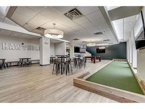 Wauwatosa apartment for rent - a game room with a green carpet and tables and chairs