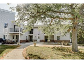 Oconomowoc apartment for rent - a courtyard with a large tree in front of some buildings