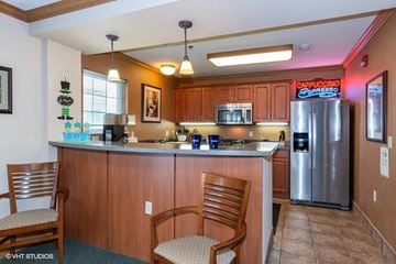 Madison apartment for rent - A kitchen with wooden cabinets and a countertop with two chairs.