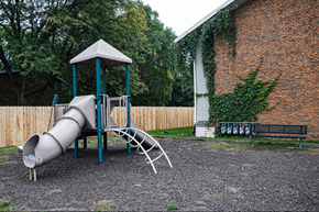 Sun Prairie townhouse for rent - A playground with a slide and a wooden fence.