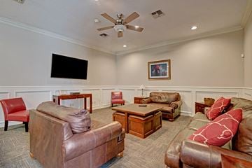 Milwaukee apartment for rent - A living room with a brown leather couch and a flat screen TV mounted on the wall.