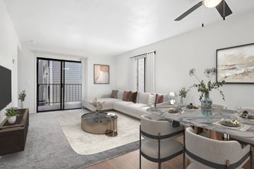 Sacramento apartment for rent - A modern living room with a glass coffee table and a grey sofa.