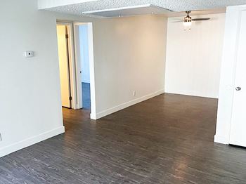 A bedroom with hardwood floors and white walls