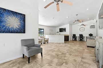 Anaheim apartment for rent - A living room with a grey armchair and a painting on the wall.