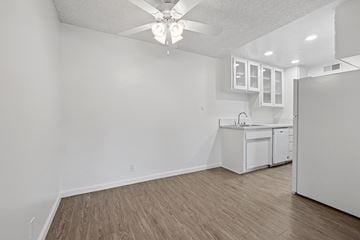 Riverside apartment for rent - A kitchen with white cabinets and a ceiling fan.