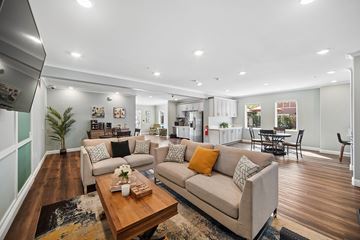 Riverside apartment for rent - A modern living room with a large couch and a coffee table.