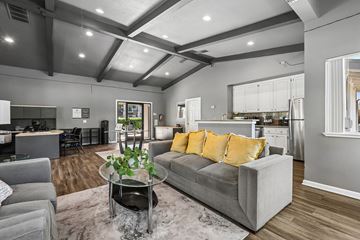 Sacramento apartment for rent - A modern living room with a grey couch and a glass coffee table.