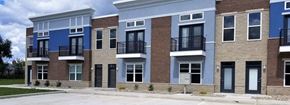 Kokomo triplex for rent - a row of brick and blue apartment buildings on a street