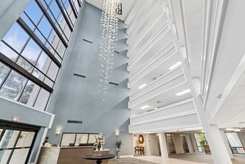 A modern interior with a chandelier and a view of the sky through the windows.