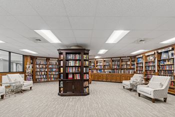 A library with bookshelves and chairs.