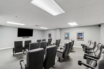 A room with a row of chairs and a television on the wall.