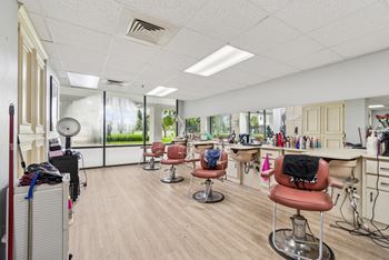 A hair salon with chairs and hairdressing stations.